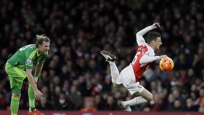 Arsenal’s Laurent Koscielny, right, goes down after a challenge from Sunderland’s Ola Toivonen during the English Premier League soccer match between Arsenal and Sunderland at the Emirates Stadium in London, Saturday Dec. 5, 2015. (AP Photo/Tim Ireland)