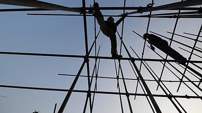 Chinese construction workers take care as they erect scaffolding on a new shopping complex. AFP Photo