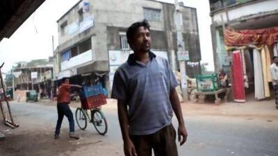 Mohammed Jahangir Alam, the elder brother of Mohammed Bohran Uddin, outside the bank in Anwara where he works as a clerk. Silvia Razgova / The National