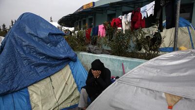 A woman sits between tents at the port of Piraeus, near Athens, on April 2, 2016. Greece is pressing ahead with plans to start sending refugees back to Turkey. Yorgos Karahalis/AP Photo