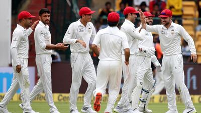 Afghanistan's Yamin Ahmadzai, second left, was one of the better bowlers for the Test debutants in Bangalore on Thursday. Aijaz Rahi / AP Photo