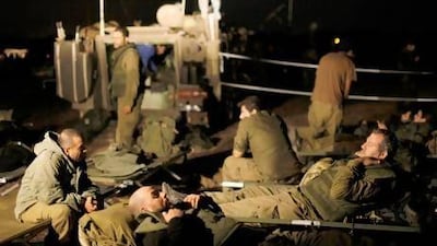 Israeli soldiers rest outside the northern Gaza Strip. Israel and Hamas agreed yesterday to a ceasefire brokered by Egypt on the eighth day of the conflict.