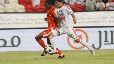 Hyungmin Shin, right, the Al Jazira defender, tussles with Ajman striker Boris Kabi during last night's match. Jaime Puebla / The National