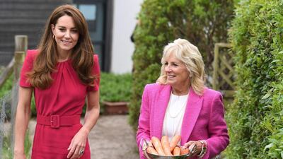 Catherine, Duchess of Cambridge talks with Jill Biden as she carries carrots to feed a pet rabbit. AFP