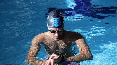 Sebastian Jensen checks on his times while training in the pool. Chris Whiteoak / The National