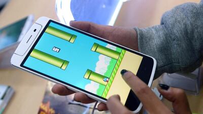 An employee plays the game Flappy Bird at a smartphone store in Hanoi. Hoang Dinh Nam / AFP