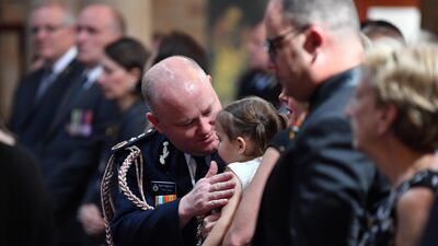Rural Fire Service Commissioner Shane Fitzsimmons talks to Charlotte O'Dwyer, daughter of NSW RFS volunteer Andrew O'Dwyer, during her father's funeral at Our Lady of Victories Catholic Church in Horsley Park, Sydney. EPA