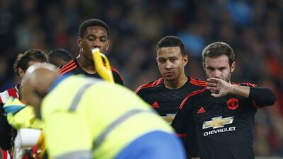 Manchester United's Juan Mata, right, Anthony Martial and Memphis Depay look on as Luke Shaw receives treatment after sustaining an injury. Reuters / Andrew Couldridge