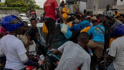 People try to get containers filled at a petrol station, amid chaotic scenes in Port-au-Prince, Haiti. AP Photo