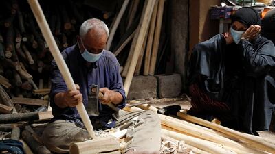 An Iraqi carpenter wears a protective mask, following the outbreak of the coronavirus disease (COVID-19), as he works at his shop in Mosul, Iraq. REUTERS