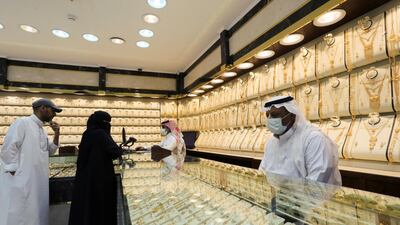 Saudi jewellers wearing protective face masks stand as people shop at a store in Riyadh. Reuters