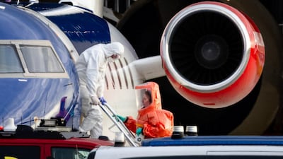 A person wearing a white hazmat suit leaves a plane believed to be carrying passengers from the hantavirus-hit cruise ship MV Hondius, before being escorted to an ambulance, at Amsterdam's Schiphol Airport in the Netherlands. AFP