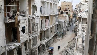 Residents walk near damaged buildings in the Old City of Aleppo, Syria. Abdalrhman Ismail/Reuters