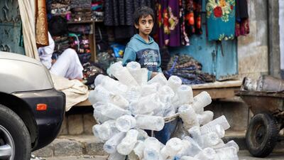 A Yemeni child collects old water bottles at a market in Sanaa's Suq Al Melh (Salt Market) on January 24, 2017. Mohammed Huwais / AFP
