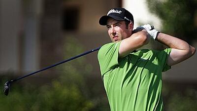 Ross Fisher watches a shot on his way to matching the course record and a share of the lead.