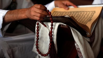 A man holds a prayer bead as he reads the holy Koran at a mosque during Ramadan amid the ongoing coronavirus pandemic. EPA