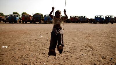 A boy plays on a makeshift swing near a slum area of the Akhdam community, where he lives.