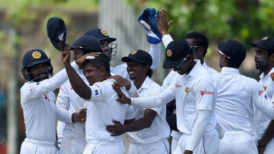 Rangana Herath, second left, is mobbed by his Sri Lanka teammates after completing a hat-trick of wickets against Australia. Ishara S Kodikara / AFP