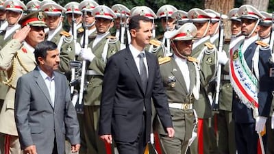 The Iranian president, Mahmoud Ahmadinejad, left, and his Syrian counterpart, Bashar Assad, review an honour guard yesterday in Tehran. Atta Kenare / AFP