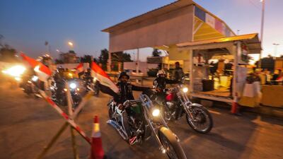 Motorcyclists cross a checkpoint as they celebrate the re-opening of the Green Zone. AFP