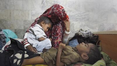 A woman displaced from a drought-stricken area in Tharkarpar with her children at a hospital in Sindh province. Akhtar Soomro / Reuters / March 11, 2014