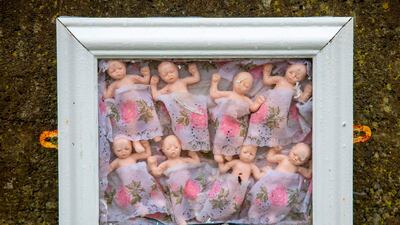 Framed baby dolls are pictured at a shrine in Tuam, County Galway, which was erected in memory of up to 800 children who were allegedly buried at the site of the former home for unmarried mothers. AFP