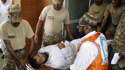 Soldiers help emergency workers wheel an injured man to a hospital after an attack on an air force base in Peshawar, Pakistan. Khuram Parvez / Reuters