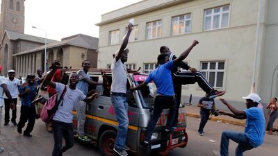 People celebrate outside parliament after hearing the news that president Robert Mugabe had resigned in Harare. Kim Ludbrook / EPA