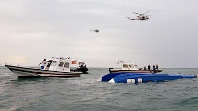 Boats and helicopters hover near the upended Victory 1 racing boat, which crashed during a competition on Friday, killing Mohammed al Mehairi and Jean-Marc Sanchez.