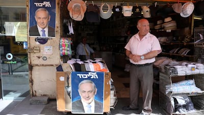 A man stands near posters of Benjamin Netanyahu during his tour at the Mahane Yehuda market. EPA