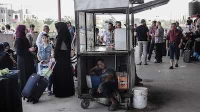 Palestinians wait for travel permits to cross into Egypt through the Rafah border crossing after it was partially opened by Egyptian authorities, in Rafah in the southern Gaza Strip, on August 16, 2017. Said Khatib / AFP Photo