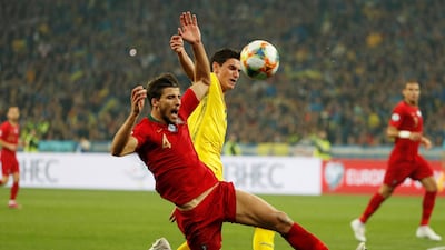 Portugal's Ruben Dias in action with Ukraine's Roman Yaremchuk. Reuters