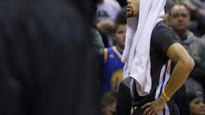 Golden State Warriors guard Stephen Curry looks up from the bench during their loss to the Milwaukee Bucks in the NBA on Saturday night. Aaron Gash / AP / December 12, 2015