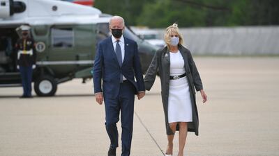 Jill Biden, wearing a white dress and grey duster coat, boards Marine One with President Joe Biden on May 3, 2021. AFP