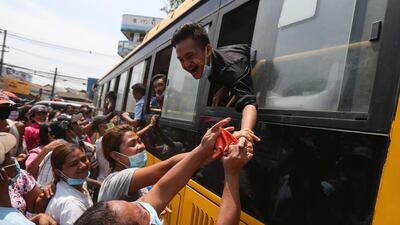 A prisoner reaches out from a bus to shake hands with family members after being released from the Insein prison in Yangon, Myanmar. AP Photo