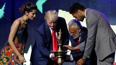 Republican Hindu Coalition chairman and a member of Hindus for Trump Shalabh Kumar (second right) helps the presidential candidate light a ceremonial diya lamp at a Bollywood-themed charity concert on October 15, 2016. Jonathan Ernst/Reuters