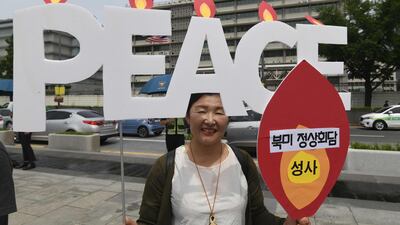 A protester holds signs during an anti-Trump rally near the US embassy in Seoul on May 25, 2018. Jung Yeon-je / AFP