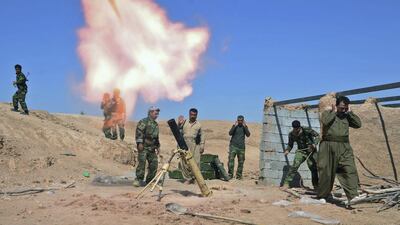 Kurdish peshmerga fighters fire a mortar during clashes with ISIL militants in the Al Zerga area near Tikrit city, in Salahuddin province on October 8, 2014. UK troops are in Erbil to train Kurdish fighters on how to use the heavy machine guns Britain supplied in September. Reuters