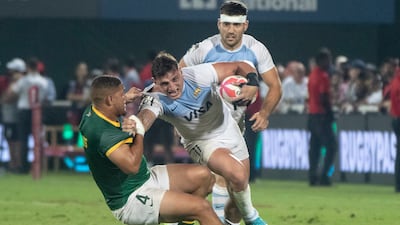 An Argentina player is tackled.