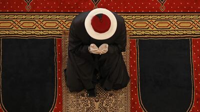 A Sunni cleric wearing protective protective gloves prays at the Mohammed Al-Amin Mosque in Beirut's downtown district. AFP