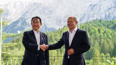 Mr Scholz shakes hands with Mr Kishida. EPA
