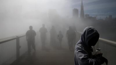 Visitors walk across the Fog Bridge at the Exploratorium in San Francisco, California. The Exploratorium’s Fog Bridge, created by Japanese artist Fujiko Nakaya, is a 150 foot bridge that links piers 15 and 17 using water pumped at high pressure through more than 800 nozzles along the bridge to create a misty fog-like environment. (Justin Sullivan / Getty Images / AFP / March 7, 2014)