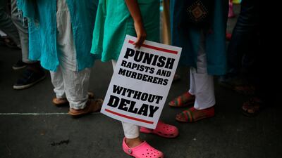 In this April 15, 2018 photo, an Indian protester stands with a placard during a protest against two recently reported rape cases as they gather near the Indian parliament in New Delhi. Oinam Anand / AP