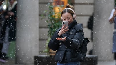 Taking photos of falling snow in Covent Garden, central London. PA