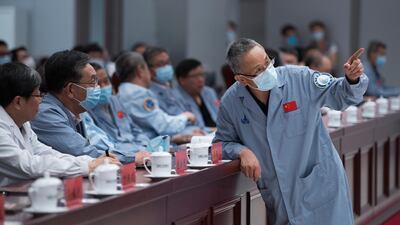 Zhang Rongqiao, right, the chief designer of China's Mars exploration mission, talks with Wu Weiren, second from left, the chief designer of China's lunar exploration project, at the Beijing Aerospace Control Center in Beijing, May 22, 2021. Xinhua via AP