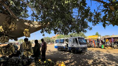 A bus drives past a fruit vendor in the Jarif West district of Sudan's capital Khartoum. AFP