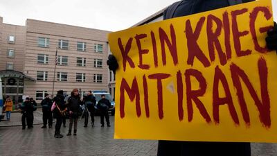 A protester holds up a placard reading 'No War with Iran' during a demonstration in front of the US embassy in Berlin on January 4, 2020. Demonstrators from different groups protested against the US attack on Iraq's capital Baghdad International Airport, in which Iran's elite forces head Qasem Suleimani and nine others were killed. AFP