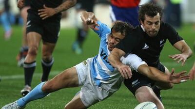 All Blacks' Conrad Smith struggles to reach the ball against Juan Martin Hernandez of Argentina during their Rugby Championship encounter in Wellington