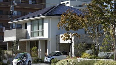 Above, a Toyota super-compact electric vehicle, left, and a Toyota compact electric vehicle parked outside a model smart home in Toyota City. Toyota has issued a $1.75 billion green asset-backed bond — backed by car leases and loans that are earmarked for future green vehicles. Kiyoshi Ota / Bloomberg News