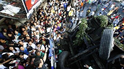 Pedestrians walk beside an overturned bus at Bicutan after the bus fell off an elevated expressway and crashed into a van below in Taguig city, south of Manila. At least 22 people were killed during the incident. Romeo Ranoco / Reuters